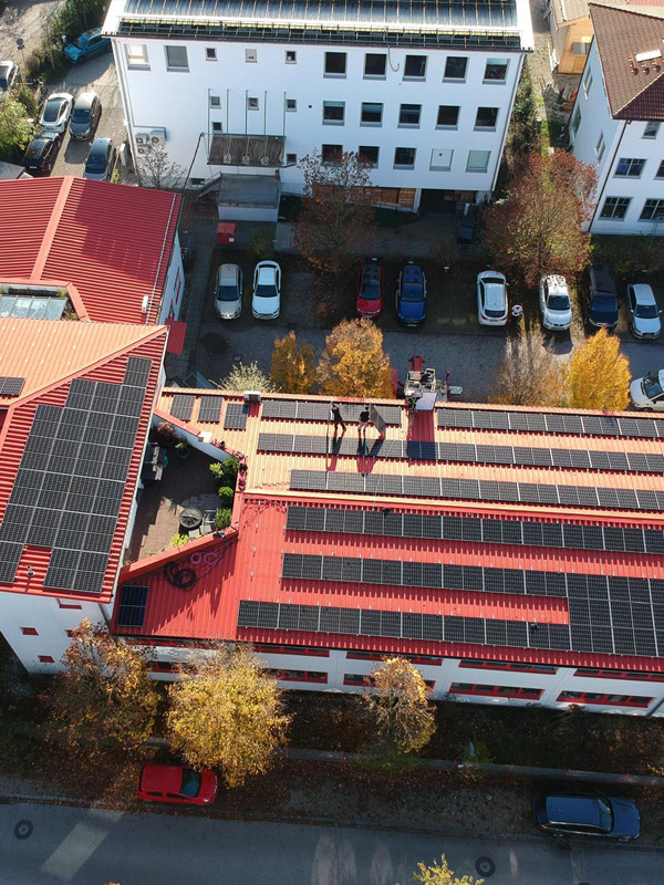 Große Aufdach-Photovoltaikanlage auf einem Gewerbegebäude (Drohnenaufnahme)
